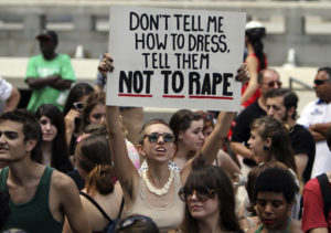 A participant holds up a sign during the Slut Walk demonstration in Philadelphia, on Saturday, Aug. 6, 2011.  Organizers of the walks aim to raise awareness for womenÃ­s issues including the fact that no woman asks to be raped because of her style of dress. (AP Photo/Joseph Kaczmarek)